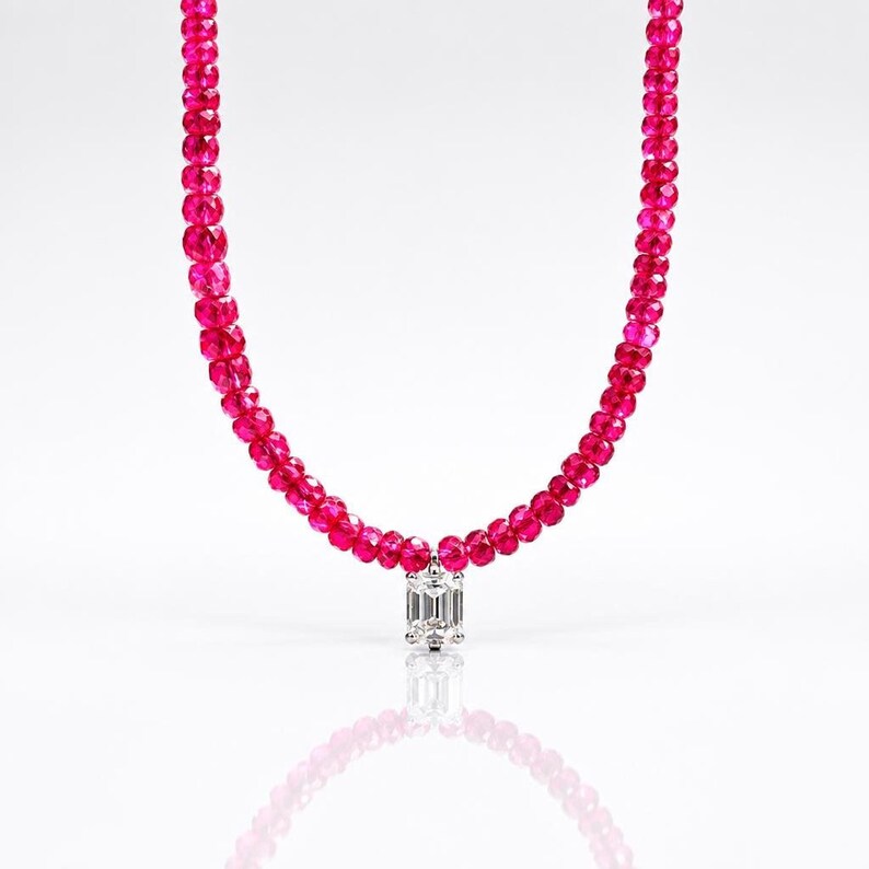 Close-up of ruby bead necklace on white background