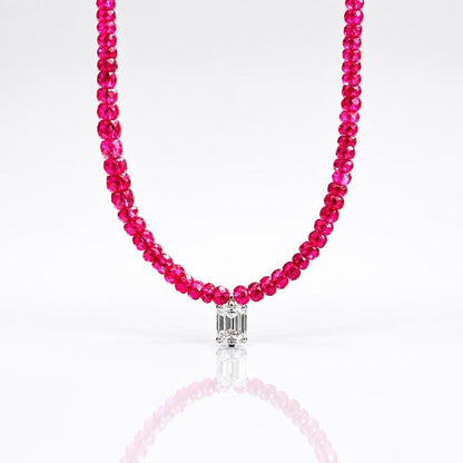 Close-up of ruby bead necklace on white background