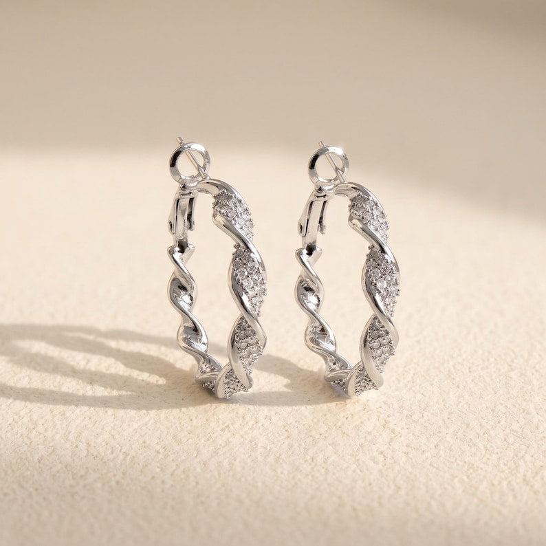 Model wearing silver twisted crystal pave hoops