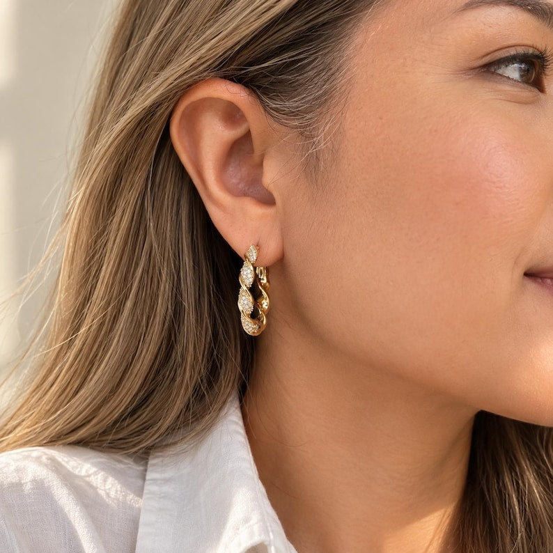 Model wearing twisted crystal pave hoop earrings
