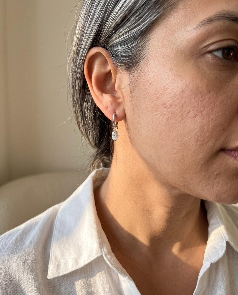 Close-up of moissanite huggie earring worn