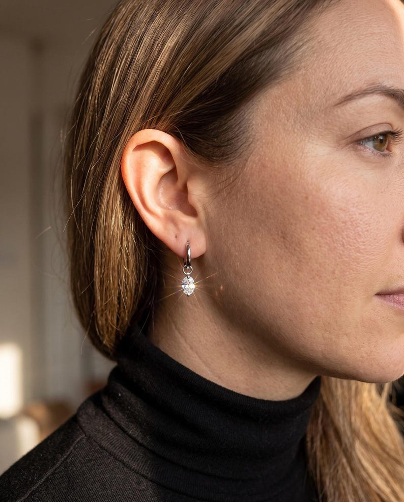 Side profile wearing black turtleneck and moissanite huggie earring