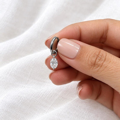 Hand holding moissanite huggie hoop earring