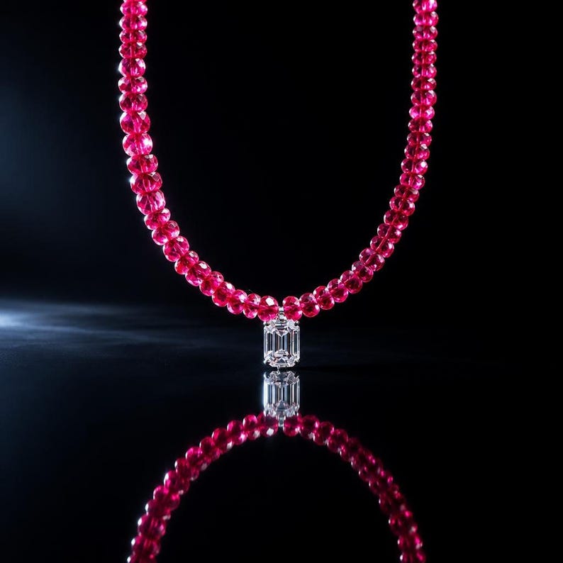 Ruby necklace suspended against dark reflective background