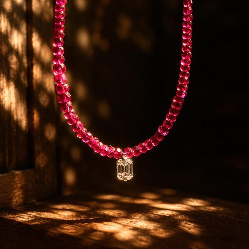 Ruby necklace in dappled sunlight against wood backdrop