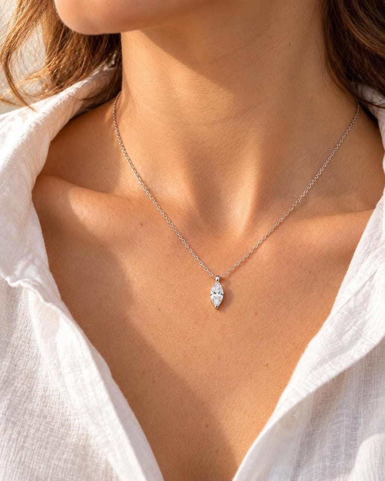 Close-up of marquise pendant necklace with white linen shirt