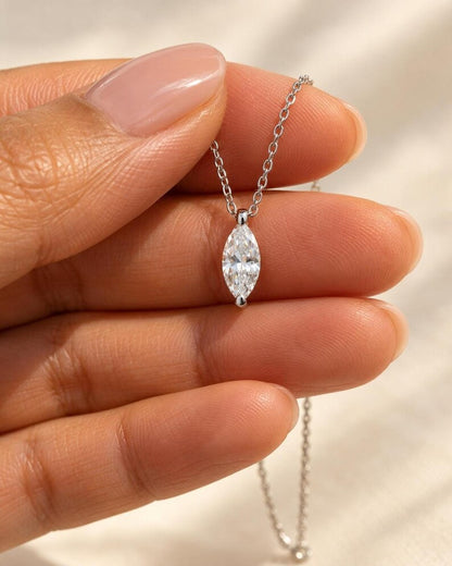 Hand holding marquise moissanite pendant necklace for scale